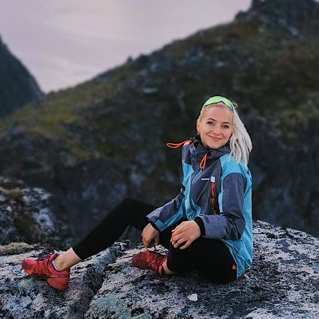 One of the founders of Lofoten Hightlights, Johanne, sitting on a mountain top in Lofoten