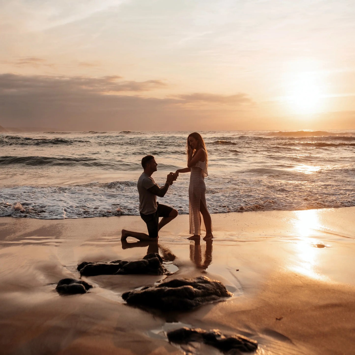 A man proposing to a woman on a beach in the sunset