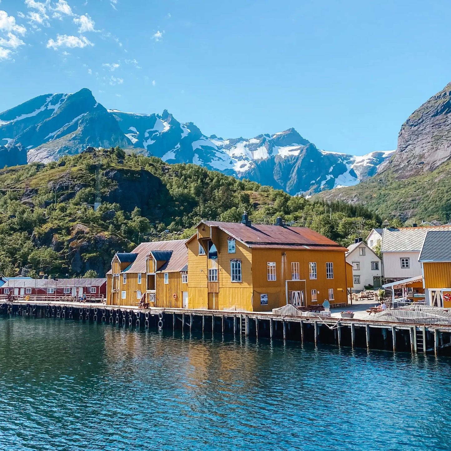 Nusfjord in Lofoten. Yellow buildings in front of steep mountains
