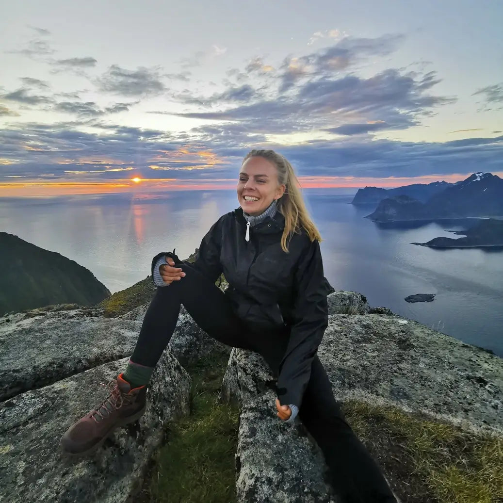 One of the founders of Lofoten Highlights, Maiken, sitting on a mountain top in Lofoten